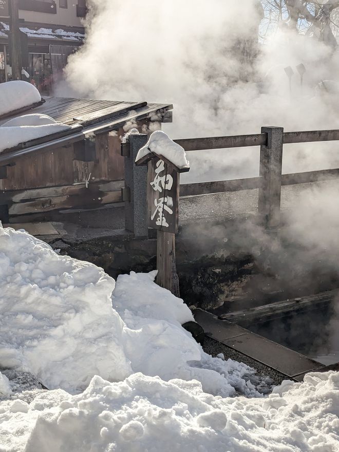 Steam rising from a Japanese onsen in the snow