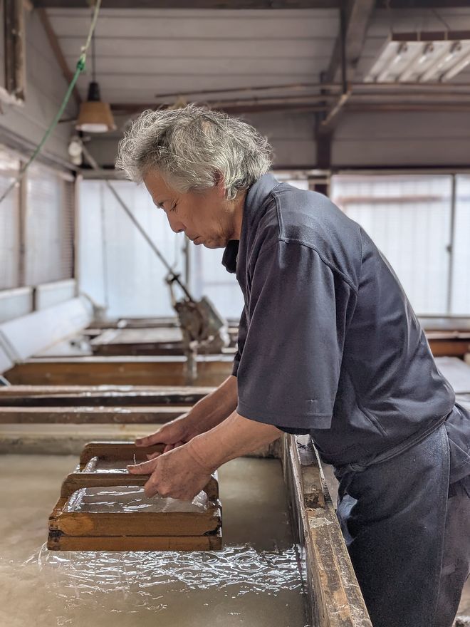 A craftsman making washi paper by hand